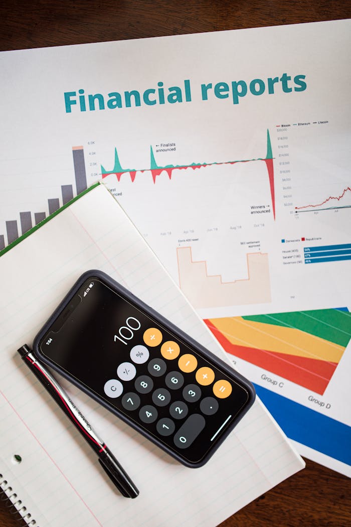 Home Top view of financial reports with a calculator app open on a smartphone.